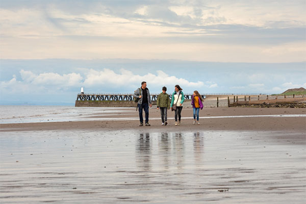 Family walking along the beach at Maryport